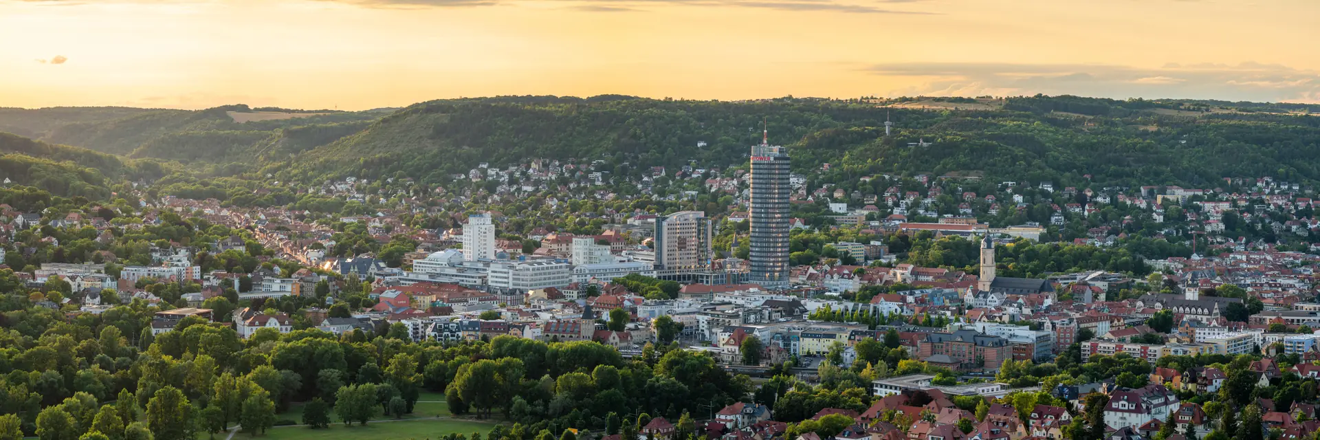 Blick über Jena im weichen Morgenlicht, im Hintergrund die bewaldeten Hänge