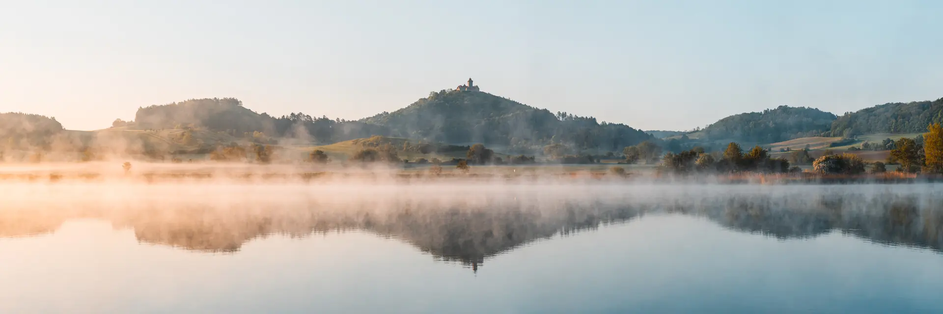 Nebel über einem See im Tal der Drei Gleichen bei Erfurt, die Burgen spiegeln sich im Wasser