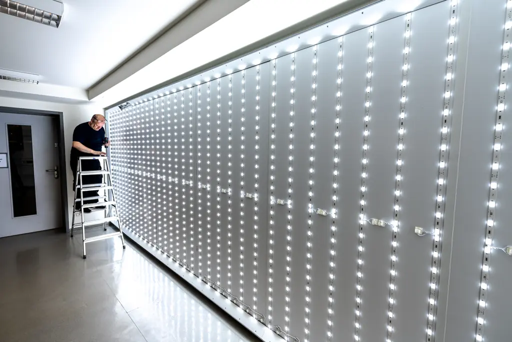 Montage eines Leuchtkastens, der Aluminiumrahmen wird an der Wand ausgerichtet