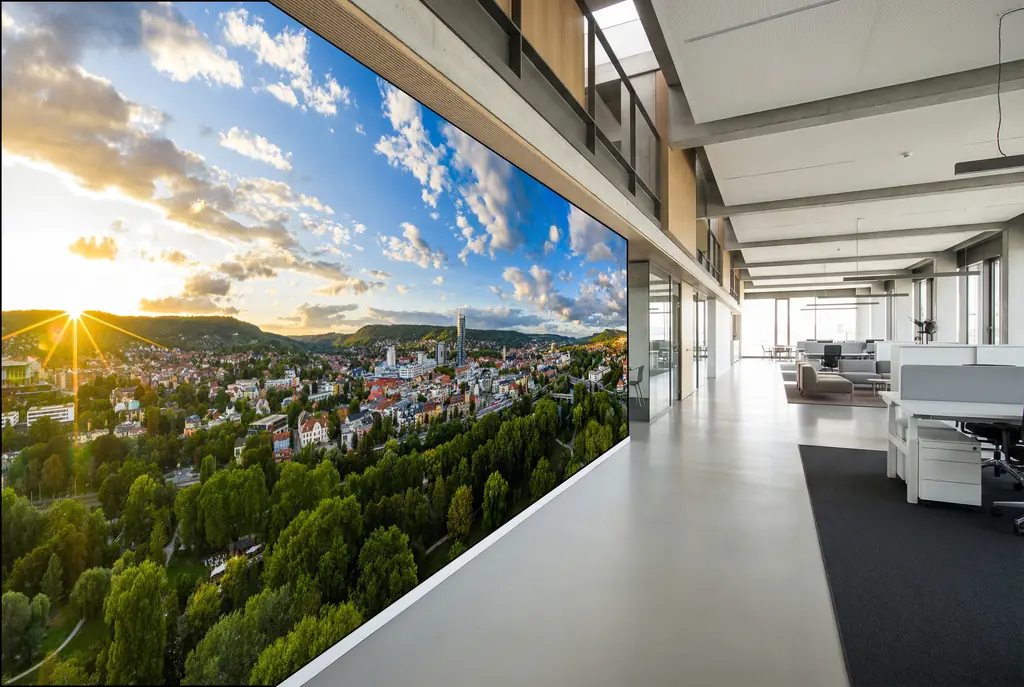 Großraumbüro mit wandfüllendem Leuchtkasten, Panorama einer Thüringer Stadt über den Arbeitsplätzen
